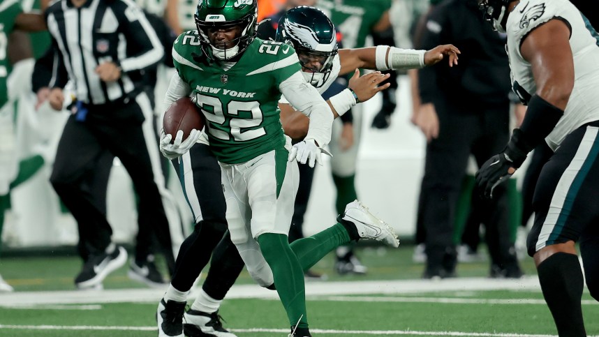 New York Jets safety Tony Adams (22) runs back an interception against Philadelphia Eagles quarterback Jalen Hurts (1) during the fourth quarter at MetLife Stadium