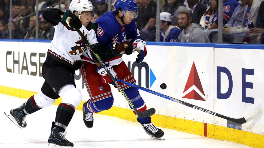 Arizona Coyotes defenseman Travis Dermott (33) and New York Rangers left wing Will Cuylle (50) fight for the puck during the second period at Madison Square Garden