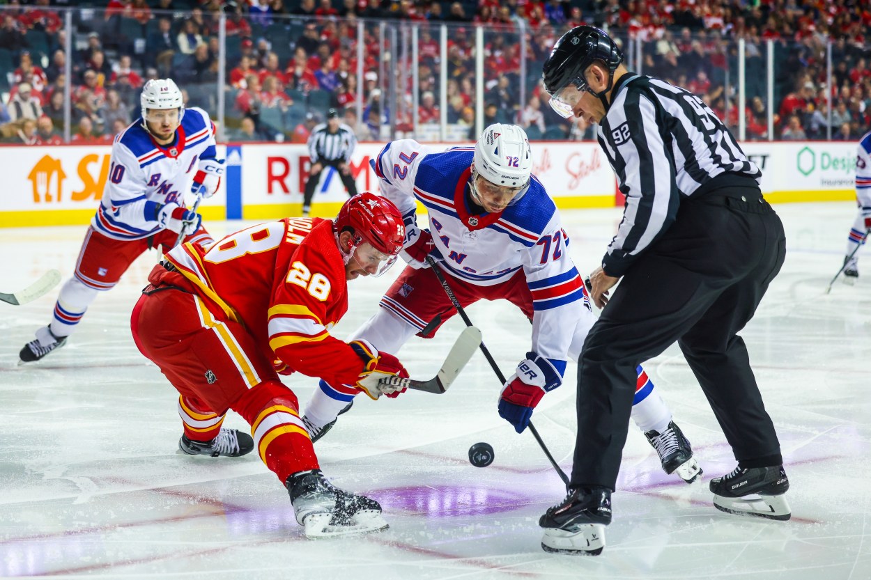 Calgary Flames center Elias Lindholm (28) and New York Rangers center Filip Chytil (72) face off for the puck during the first period at Scotiabank Saddledome