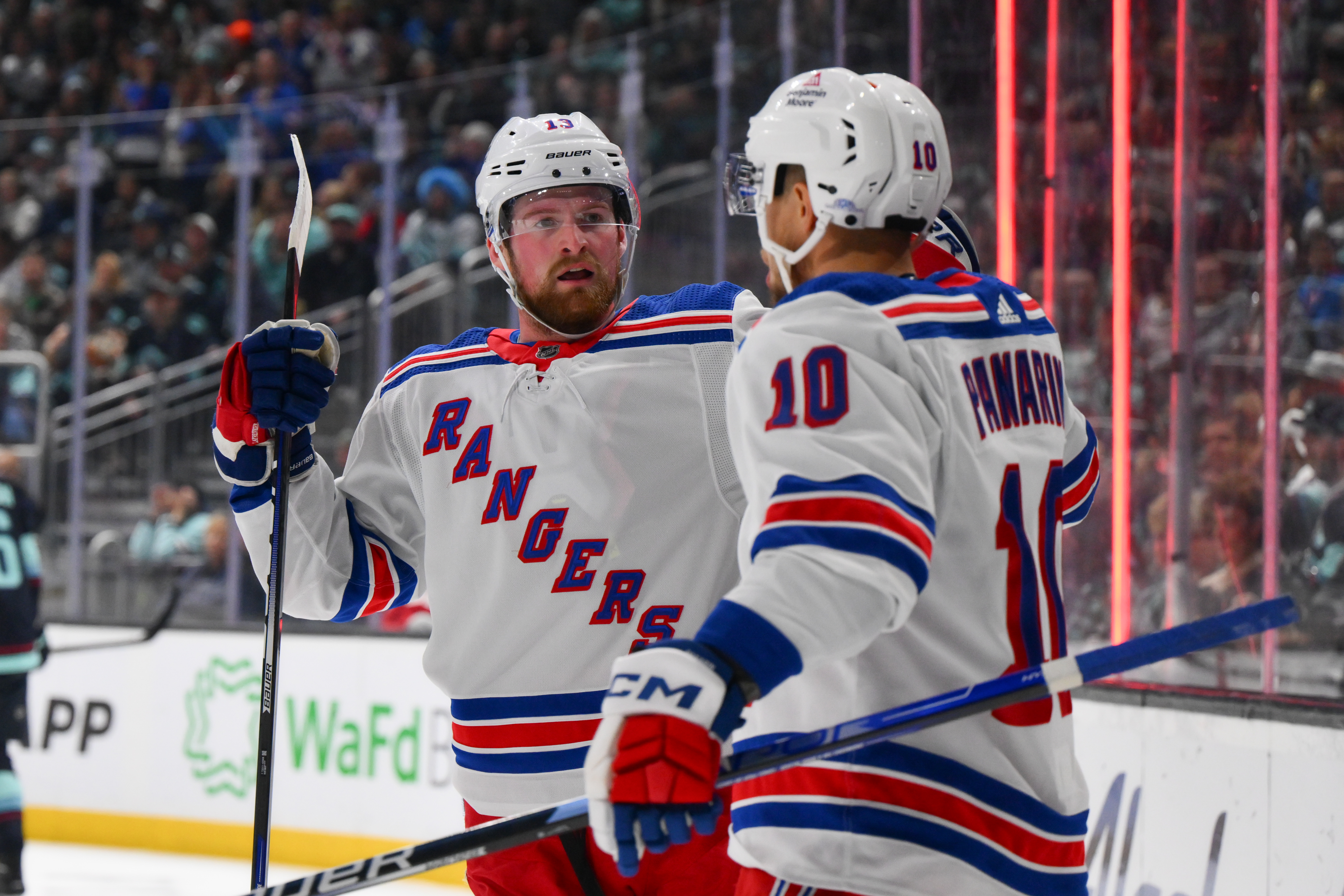 New York Rangers left wing Alexis Lafreniere (13) and left wing Artemi Panarin (10) celebrate after Panarin scored a goal against the Seattle Kraken during the first period at Climate Pledge Arena