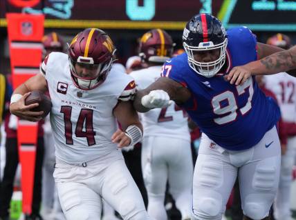 Sam Howell of the Commanders is chased by Dexter Lawrence of the Giants in the first half. The NY Giants host the Washington Commanders at MetLife Stadium in East Rutherford