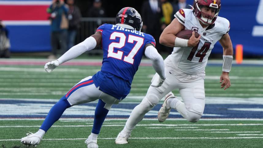 Jason Pinnock of the Giants chases Sam Howell of the Commanders in the second half. The NY Giants host the Washington Commanders at MetLife Stadium