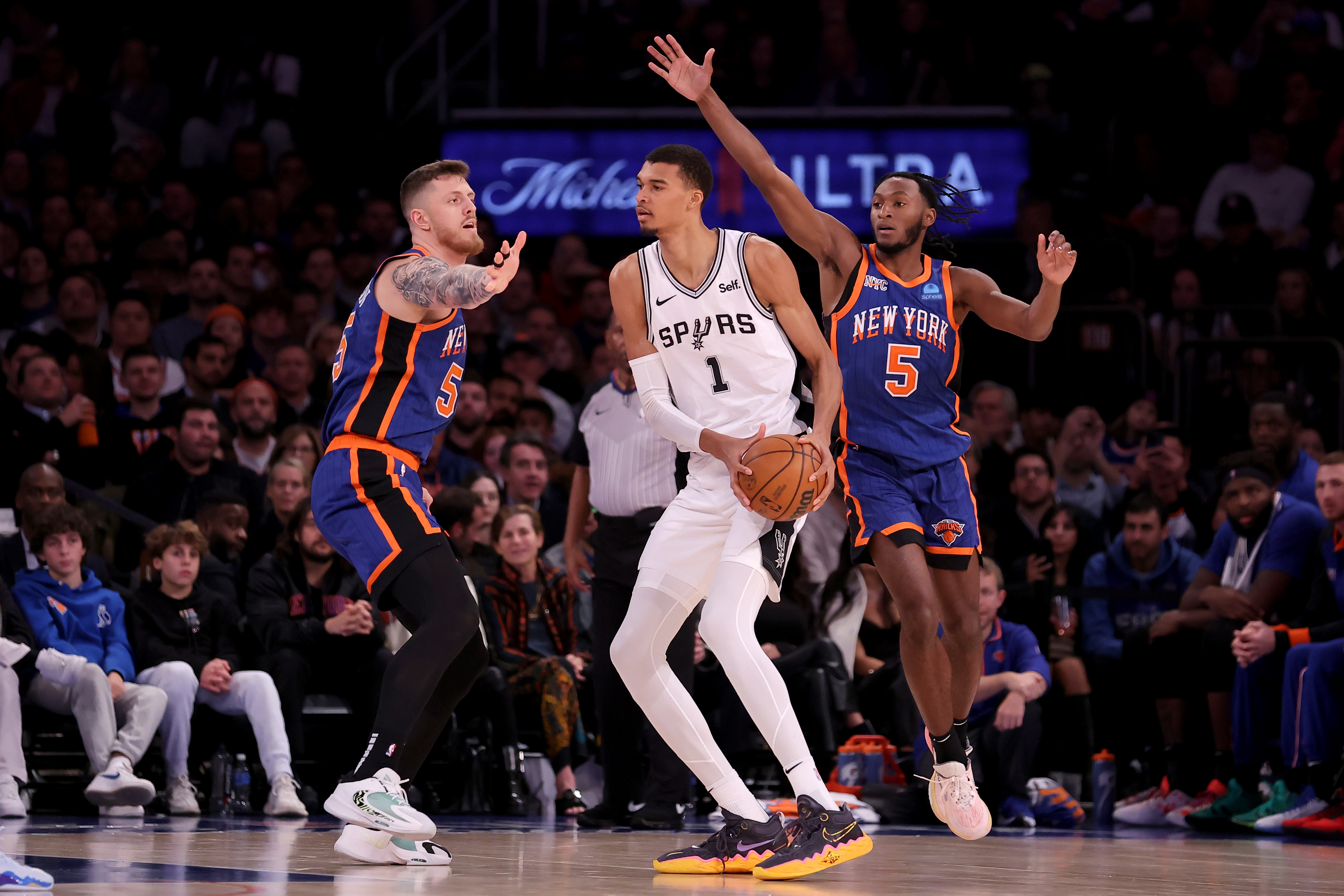 San Antonio Spurs center Victor Wembanyama (1) controls the ball against New York Knicks center Isaiah Hartenstein (55) and guard Immanuel Quickley (5) during the third quarter at Madison Square Garden