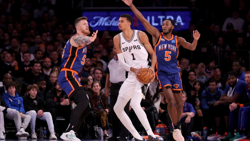 San Antonio Spurs center Victor Wembanyama (1) controls the ball against New York Knicks center Isaiah Hartenstein (55) and guard Immanuel Quickley (5) during the third quarter at Madison Square Garden