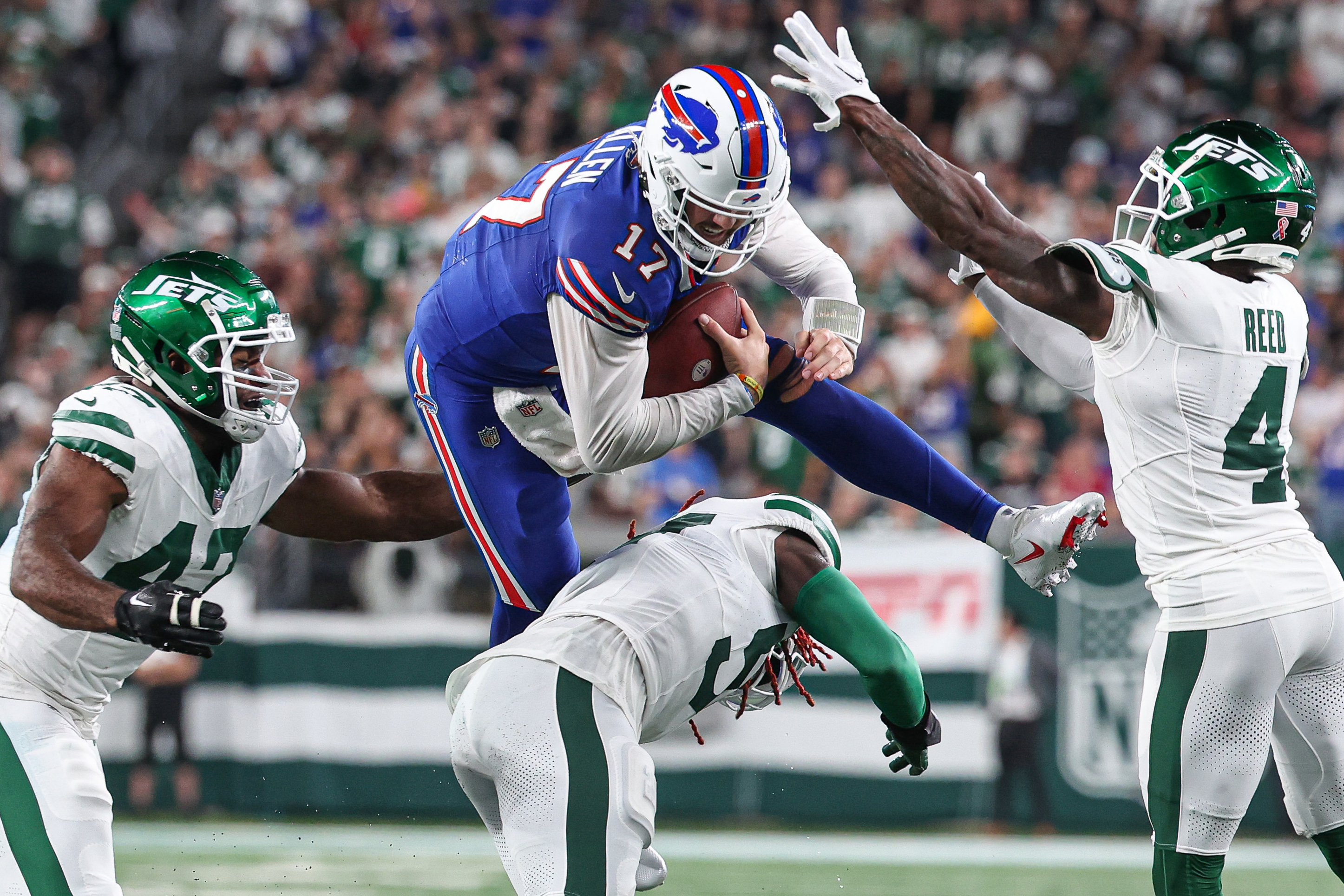 East Rutherford, New Jersey, USA; Buffalo Bills quarterback Josh Allen (17) rushes the ball as New York Jets linebacker C.J. Mosley (57) and cornerback D.J. Reed (4) and defensive end Bryce Huff (47) defend during the first half at MetLife Stadium