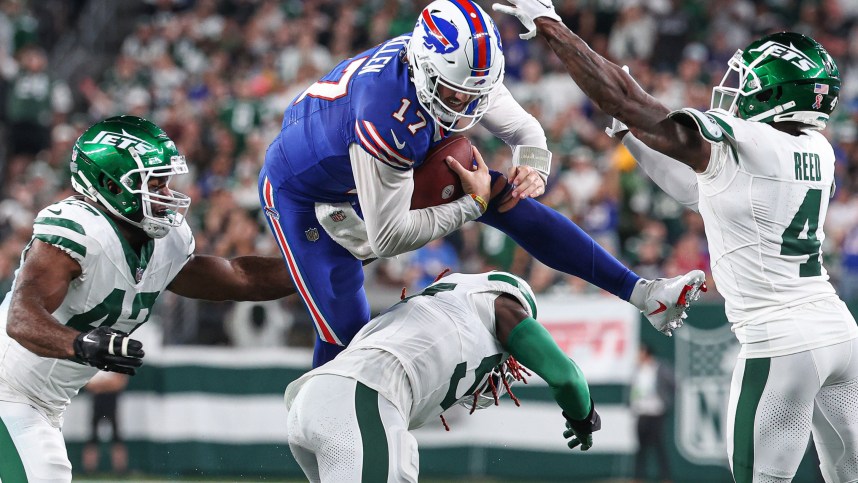 East Rutherford, New Jersey, USA; Buffalo Bills quarterback Josh Allen (17) rushes the ball as New York Jets linebacker C.J. Mosley (57) and cornerback D.J. Reed (4) and defensive end Bryce Huff (47) defend during the first half at MetLife Stadium