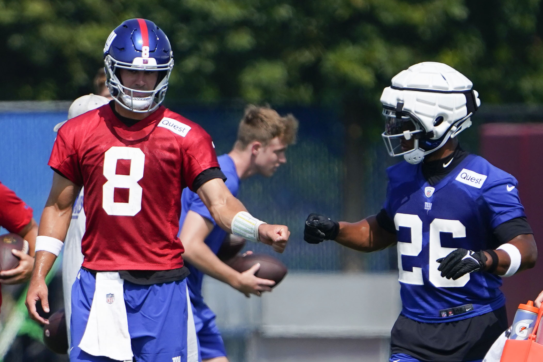 New York Giants quarterback Daniel Jones (8) and running back Saquon Barkley (26) fist-bump on the first day of training camp at the Quest Diagnostics Training Facility