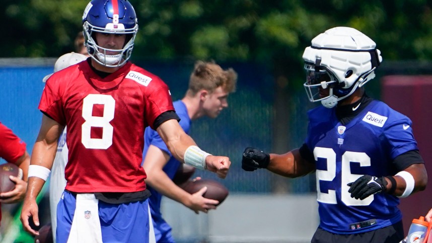 New York Giants quarterback Daniel Jones (8) and running back Saquon Barkley (26) fist-bump on the first day of training camp at the Quest Diagnostics Training Facility