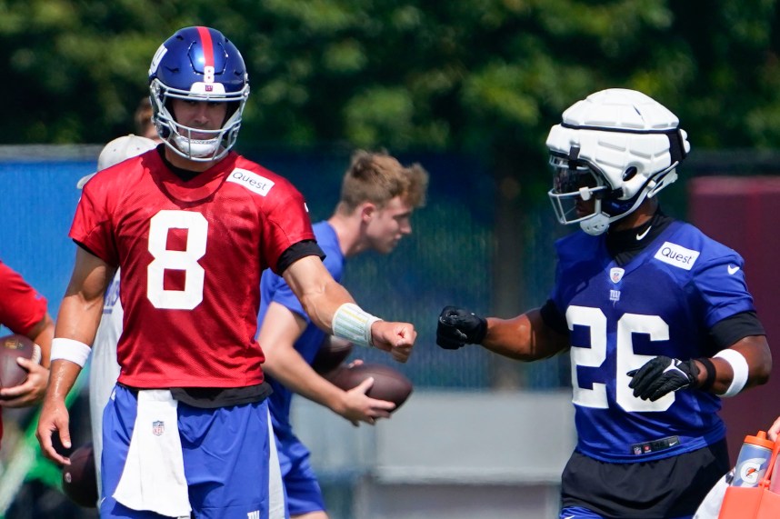 New York Giants quarterback Daniel Jones (8) and running back Saquon Barkley (26) fist-bump on the first day of training camp at the Quest Diagnostics Training Facility