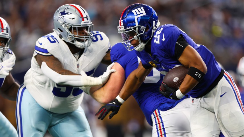 New York Giants running back Saquon Barkley (26) runs with the ball as Dallas Cowboys defensive tackle Johnathan Hankins (95) defends during the first quarter at AT&T Stadium