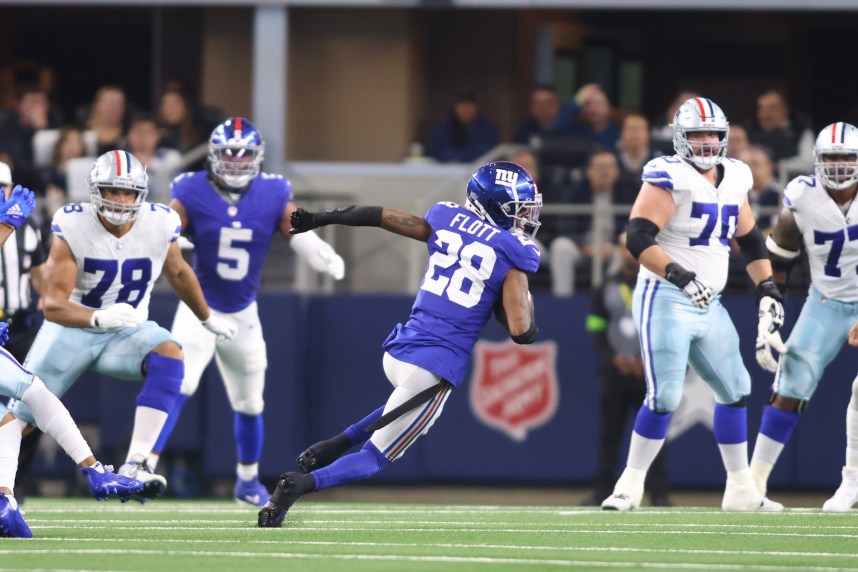 New York Giants cornerback Cor'Dale Flott (28) runs with the ball after making an interception in the first quarter against the Dallas Cowboys at AT&T Stadium