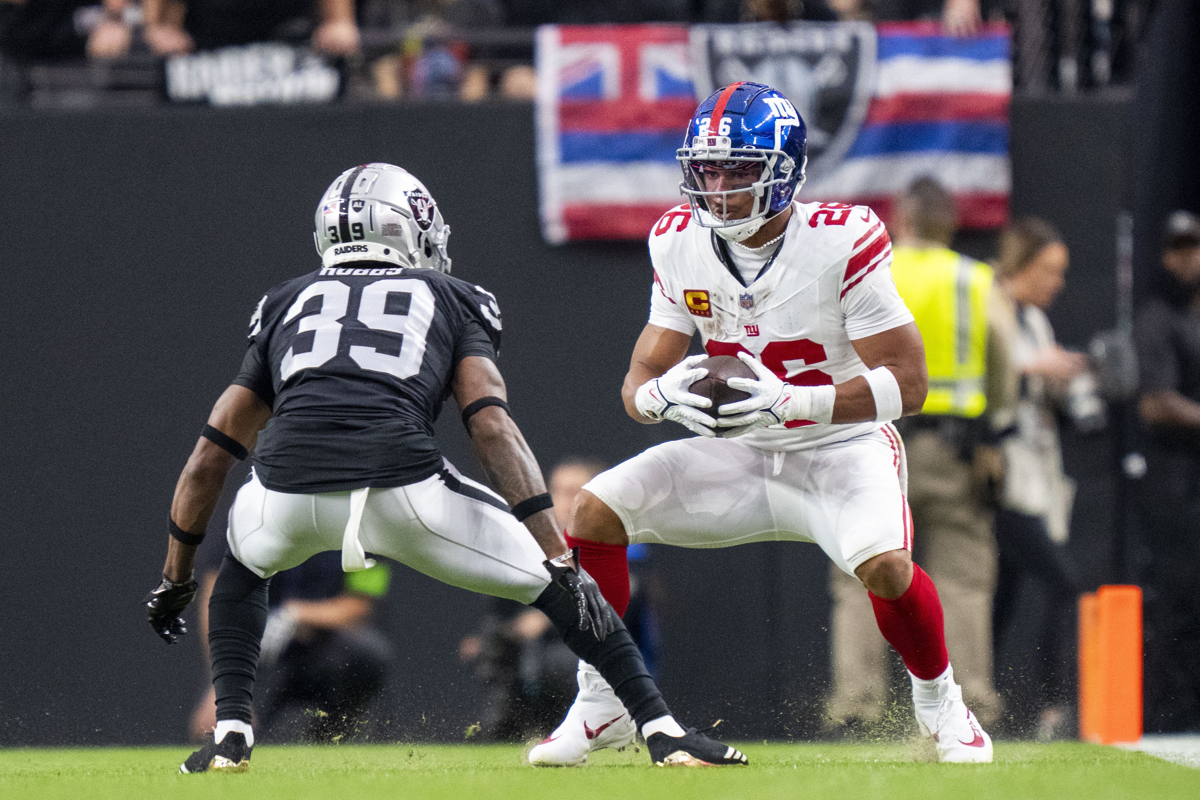 New York Giants running back Saquon Barkley (26) runs the football against Las Vegas Raiders cornerback Nate Hobbs (39) during the first quarter at Allegiant Stadium