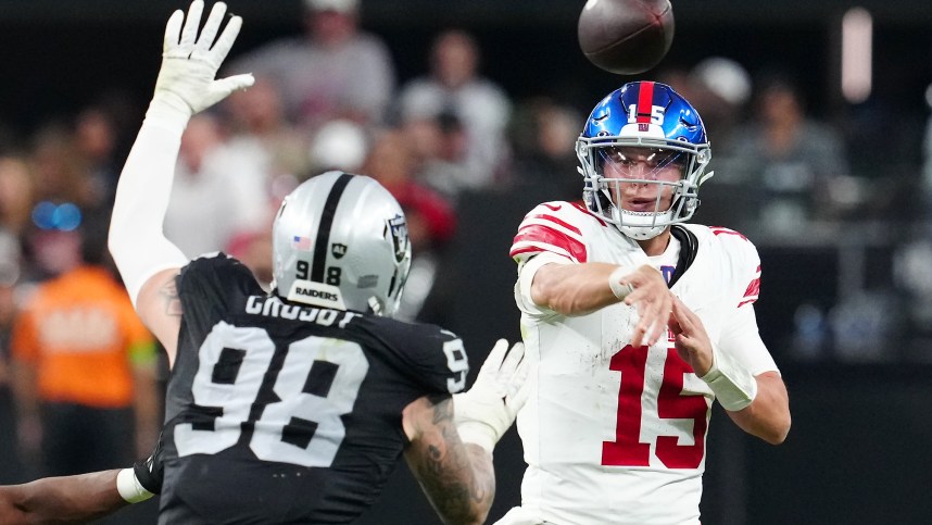 New York Giants quarterback Tommy DeVito (15) is pressured by Las Vegas Raiders defensive end Maxx Crosby (98) during the fourth quarter at Allegiant Stadium