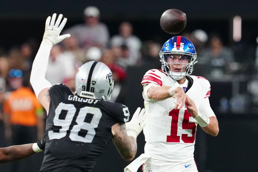 New York Giants quarterback Tommy DeVito (15) is pressured by Las Vegas Raiders defensive end Maxx Crosby (98) during the fourth quarter at Allegiant Stadium