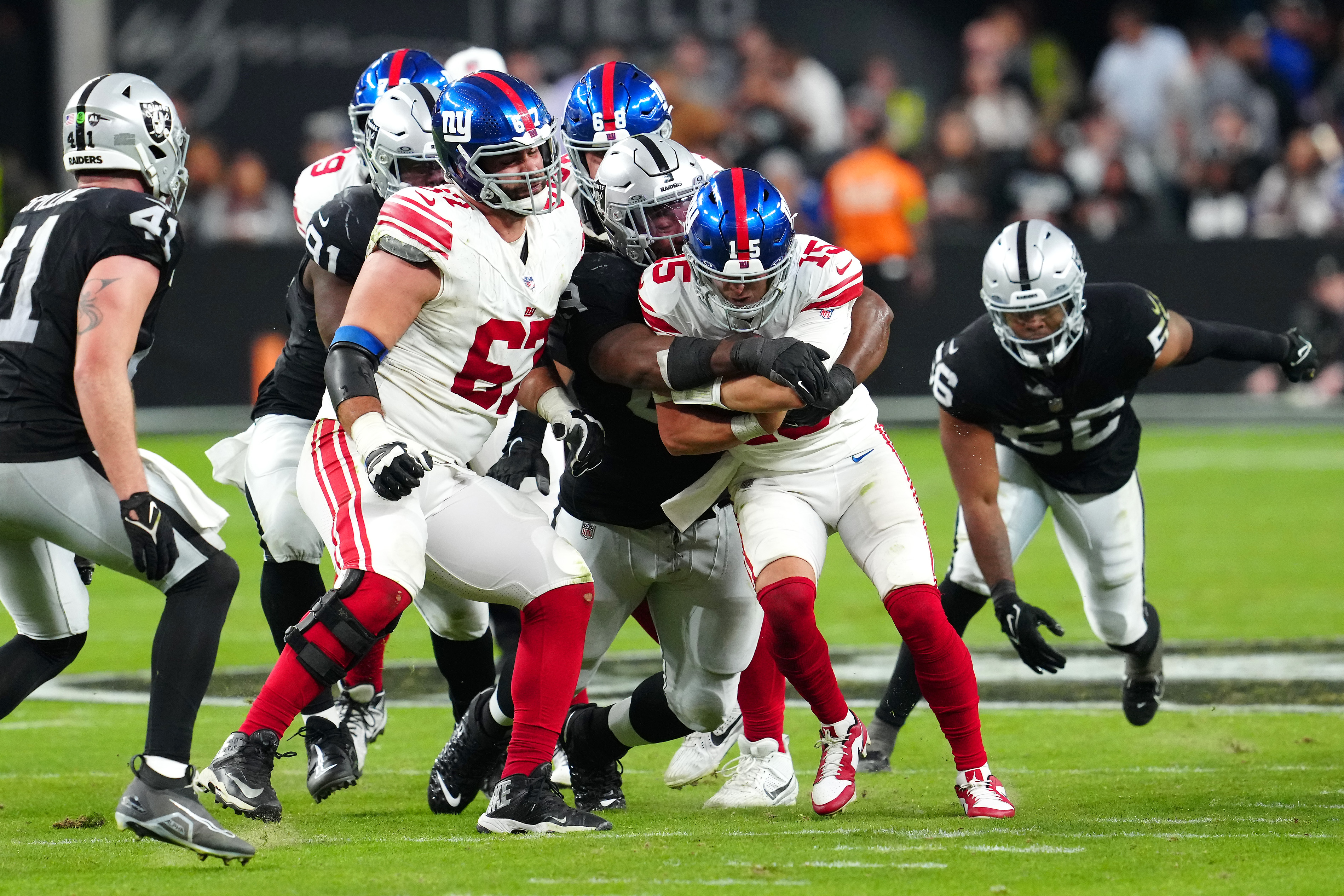 New York Giants quarterback Tommy DeVito (15) is sacked by Las Vegas Raiders defensive tackle Adam Butler (69) during the fourth quarter at Allegiant Stadium