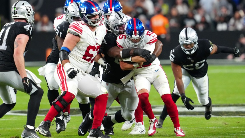 New York Giants quarterback Tommy DeVito (15) is sacked by Las Vegas Raiders defensive tackle Adam Butler (69) during the fourth quarter at Allegiant Stadium