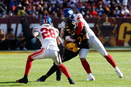 Washington Commanders tight end Logan Thomas (82) fumbles on a tackle by New York Giants linebacker Micah McFadden (41) and Giants cornerback Cor'Dale Flott (28) during the first quarter at FedExField