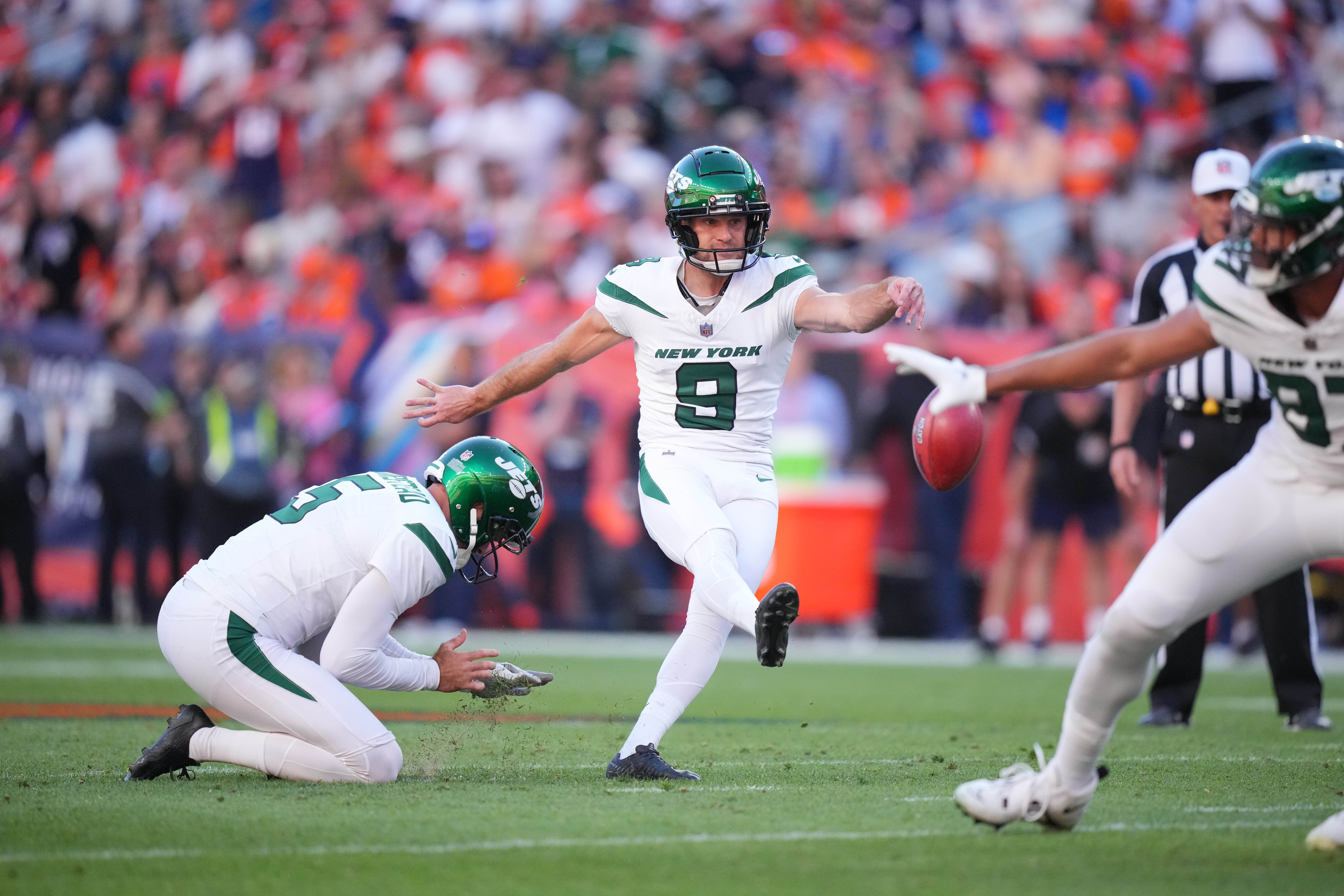 New York Jets place kicker Greg Zuerlein (9) kicks a field goal in the fourth quarter as punter Thomas Morstead (5) holds against the Denver Broncos at Empower Field at Mile High