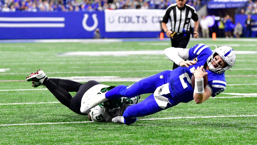Indianapolis Colts quarterback Carson Wentz (2) is tackled short of the end zone by New York Jets defensive end Shaq Lawson (50) during the second half at Lucas Oil Stadium