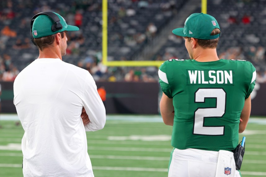 New York Jets quarterback Aaron Rodgers (8) and New York Jets quarterback Zach Wilson (2) talk during the second half of their game against the Tampa Bay Buccaneers at MetLife Stadium