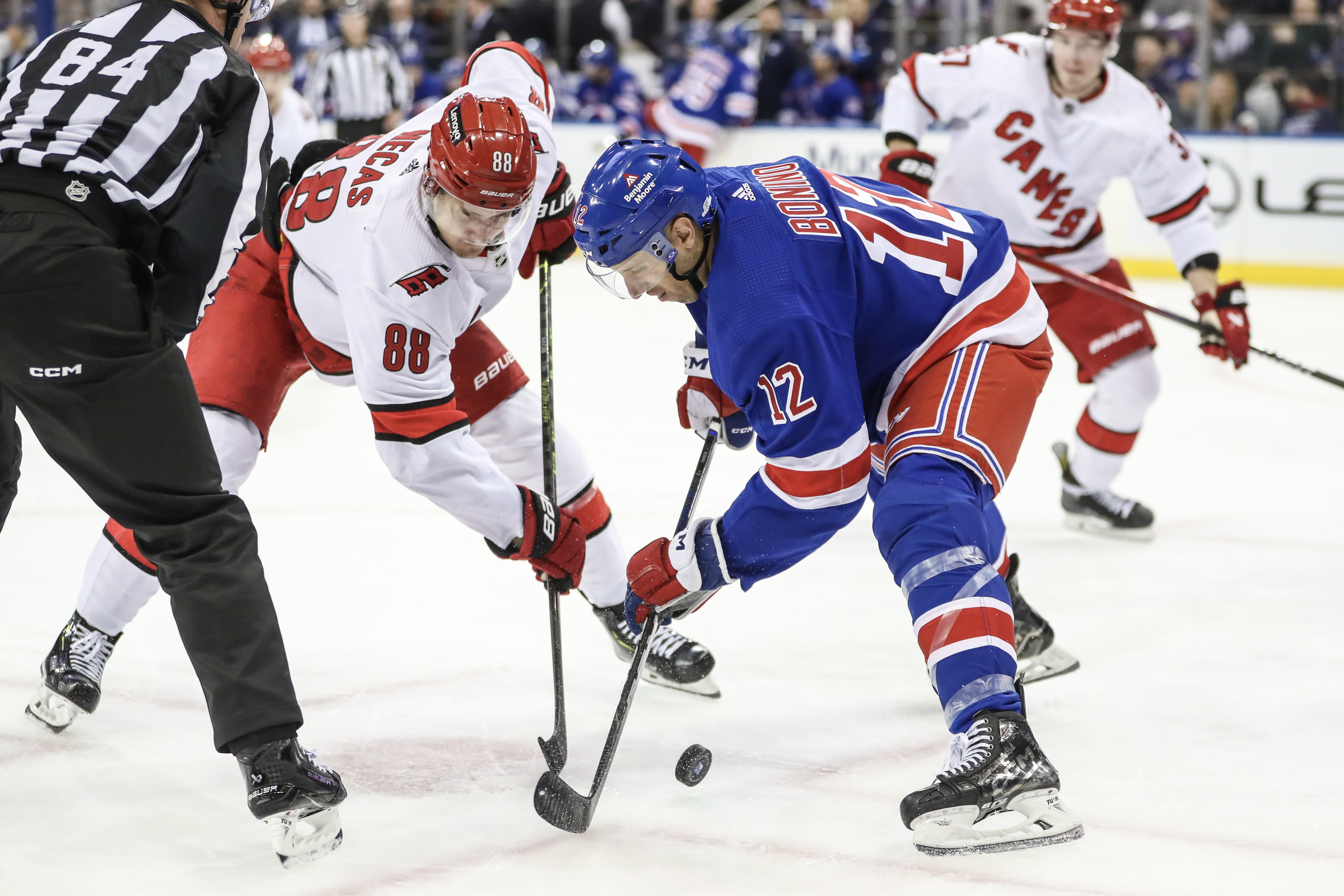 Carolina Hurricanes center Martin Necas (88) and New York Rangers center Nick Bonino (12) battle for the puck during a face-off in the third period at Madison Square Garden