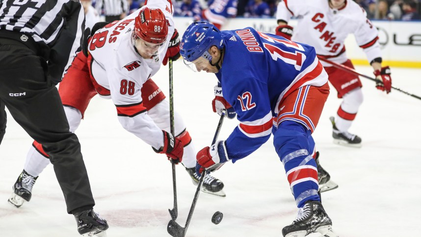 Carolina Hurricanes center Martin Necas (88) and New York Rangers center Nick Bonino (12) battle for the puck during a face-off in the third period at Madison Square Garden