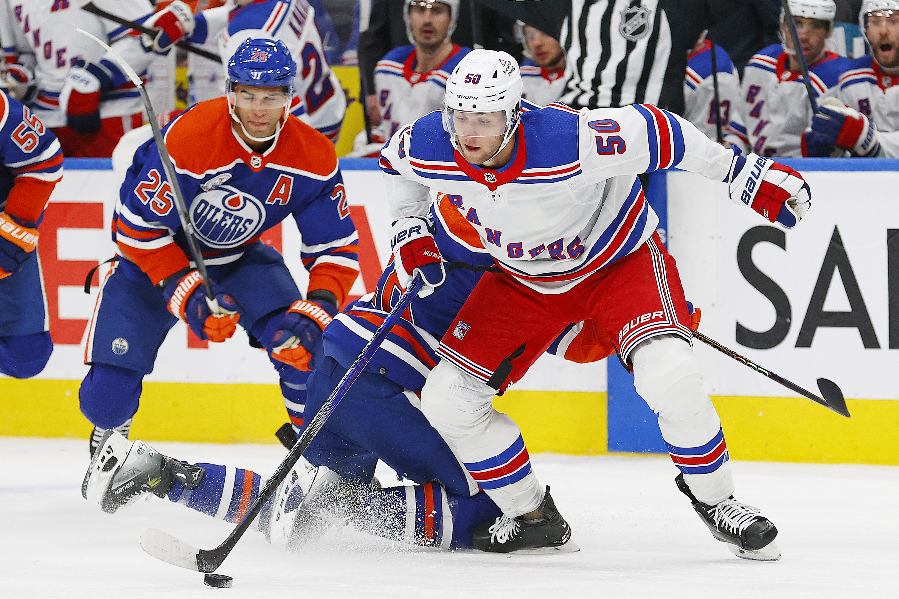 New York Rangers forward Will Cuylle (5) moves the puck around Edmonton Oilers forward Connor Brown (28) and defensemen Darnell Nurse (25) during the second period at Rogers Place