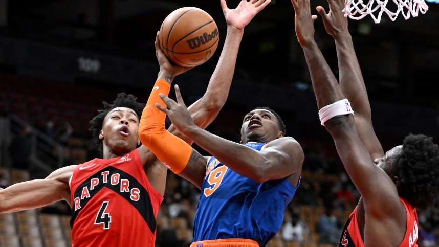 New York Knicks guard RJ Barrett (9) tries to shoot the ball as Toronto Raptors forwards Scottie Barnes (4) and OG Anunoby (3) defend in the first half at Scotiabank Arena