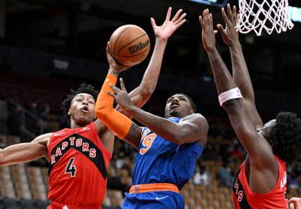 New York Knicks guard RJ Barrett (9) tries to shoot the ball as Toronto Raptors forwards Scottie Barnes (4) and OG Anunoby (3) defend in the first half at Scotiabank Arena
