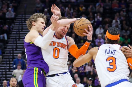 New York Knicks guard Donte DiVincenzo (0) is fouled by Utah Jazz forward Lauri Markkanen (23) during an inbound pass in the last few seconds of the game at Delta Center