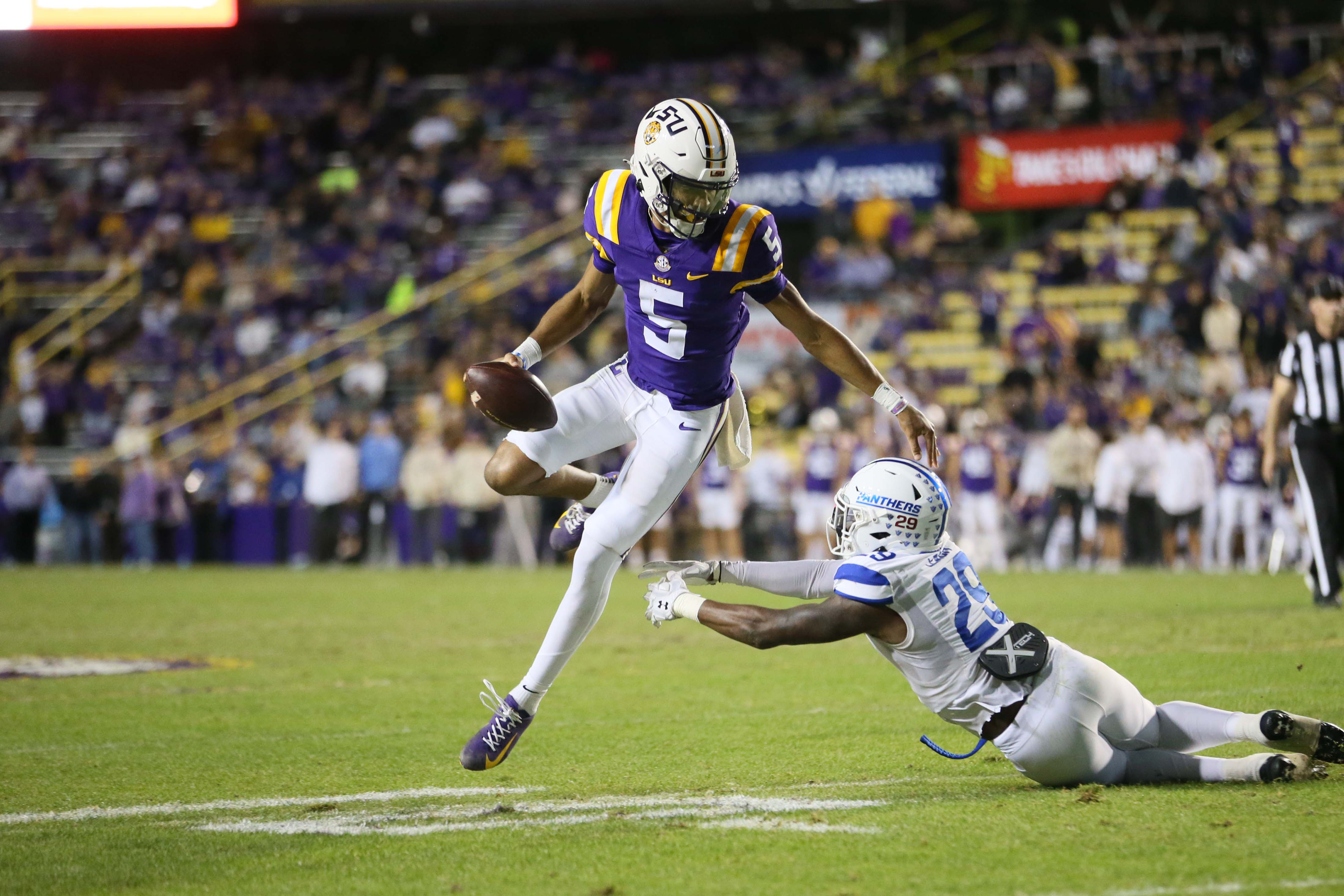 LSU Tigers quarterback Jayden Daniels (5) (New York Giants prospect) avoids the tackle attempt of Georgia State Panthers safety TyGee Leach (29) in the third quarter at Tiger Stadium, new york giants