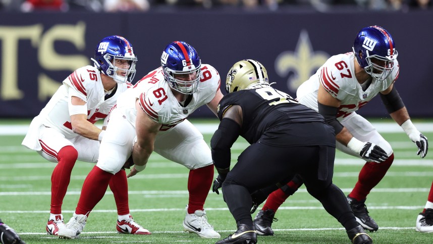 New York Giants center John Michael Schmitz Jr. (61) snaps the ball to quarterback Tommy DeVito (15) during the first half against the New Orleans Saints at Caesars Superdome