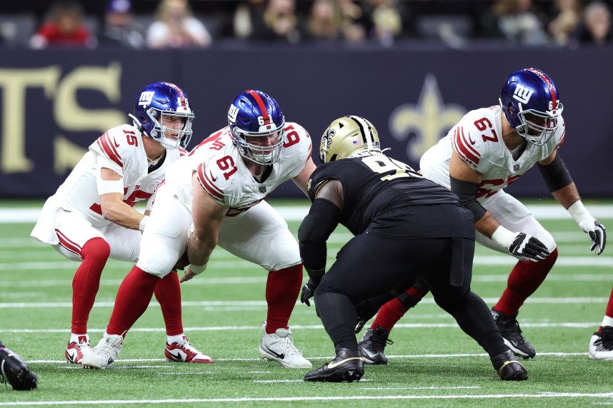 New York Giants center John Michael Schmitz Jr. (61) snaps the ball to quarterback Tommy DeVito (15) during the first half against the New Orleans Saints at Caesars Superdome