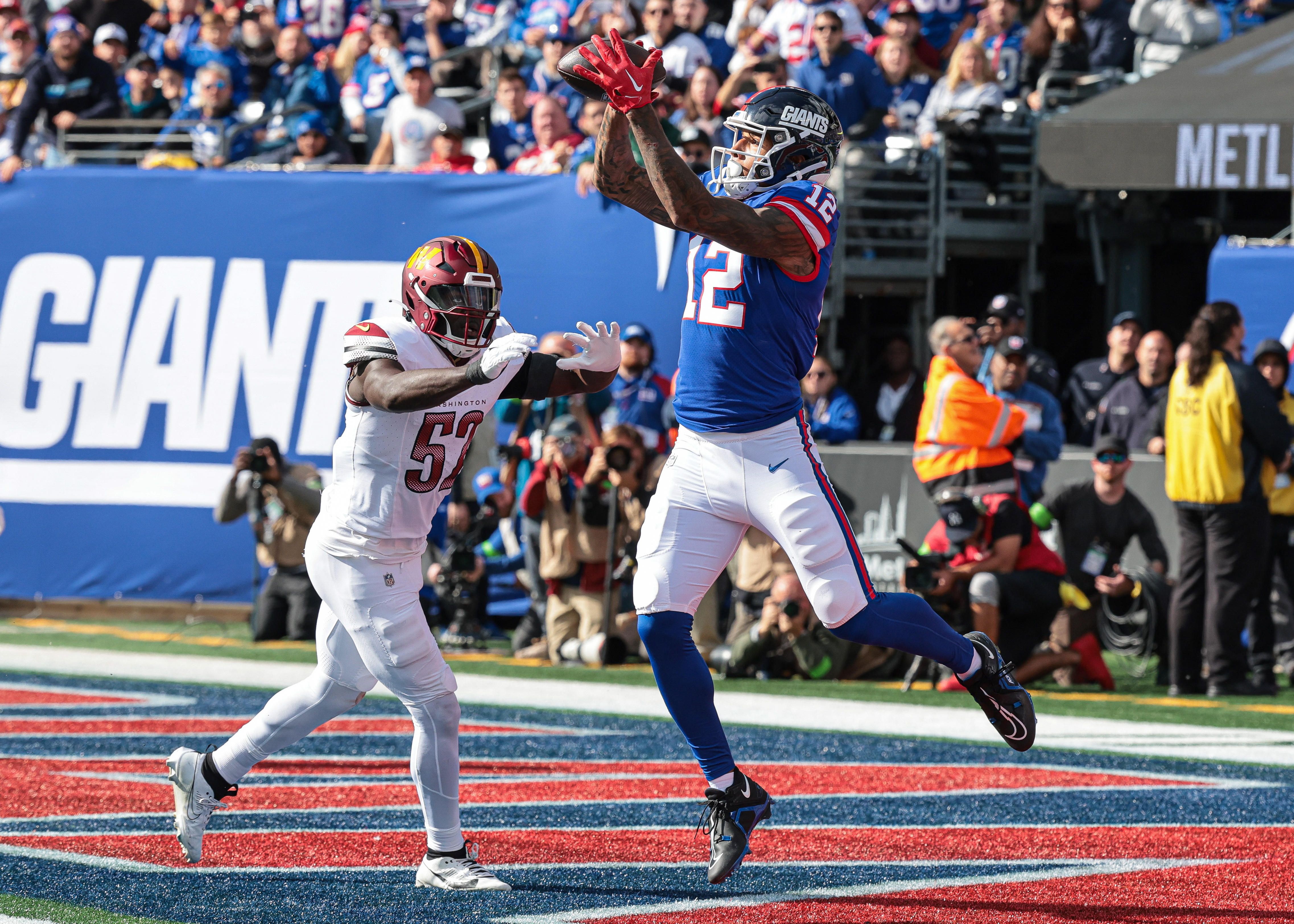 New York Giants tight end Darren Waller (12) catches a touchdown pass during the first half in front of Washington Commanders linebacker Jamin Davis (52) at MetLife Stadium