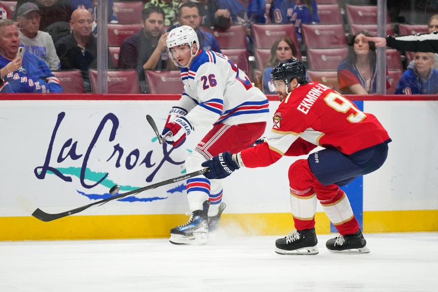 New York Rangers left wing Jimmy Vesey (26) passes the puck away from Florida Panthers defenseman Oliver Ekman-Larsson (91) during the first period at Amerant Bank Arena