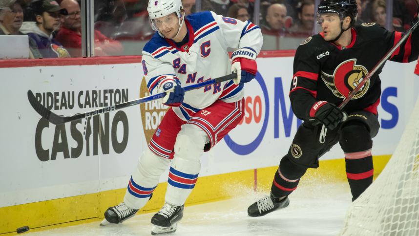 New York Rangers defenseman Jacob Trouba (8) moves the puck away from  Ottawa Senators center Josh Norris (9) in the first period at the Canadian
