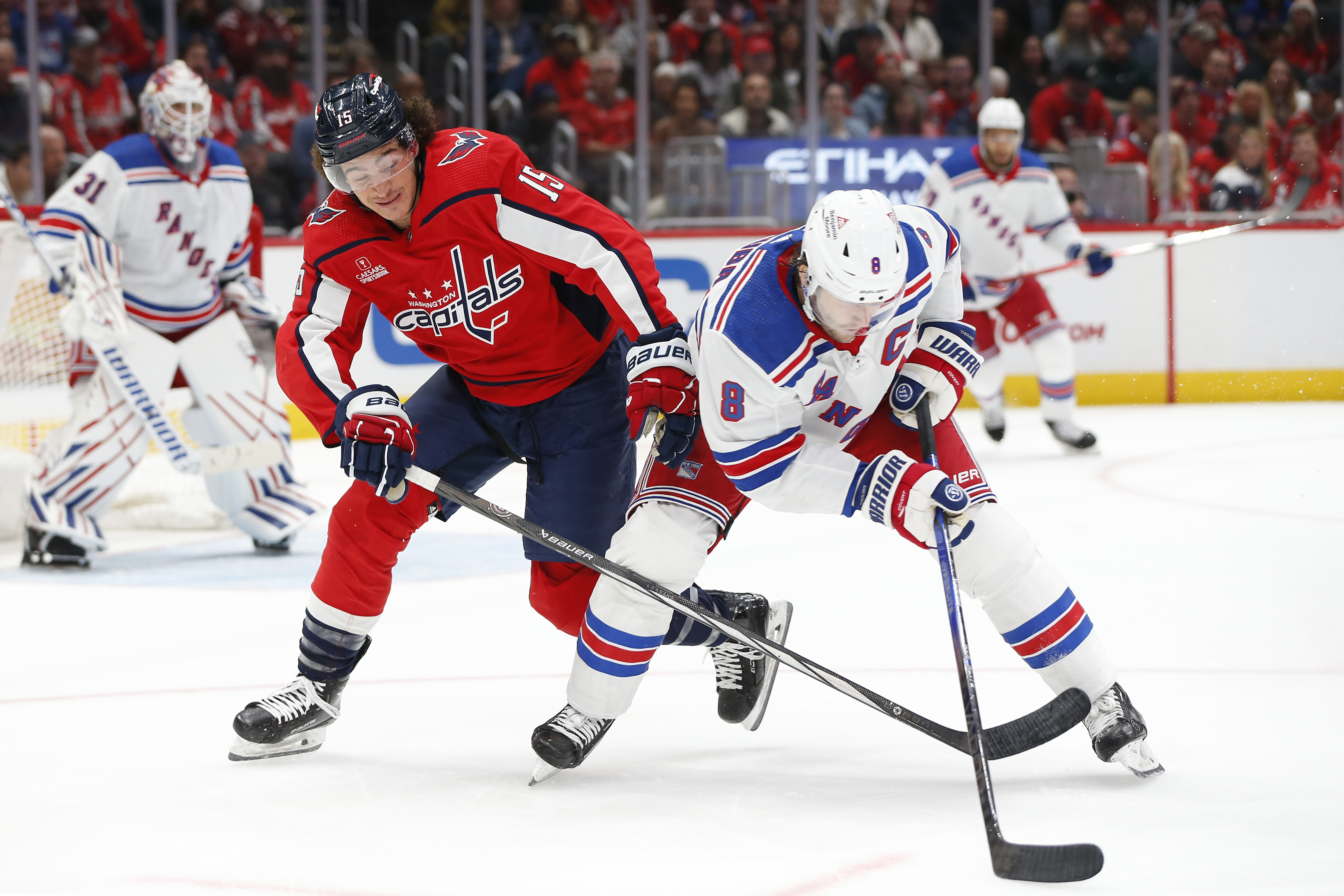 New York Rangers defenseman Jacob Trouba (8) skates with the puck as Washington Capitals left wing Sonny Milano (15) defends during the first period at Capital One Arena