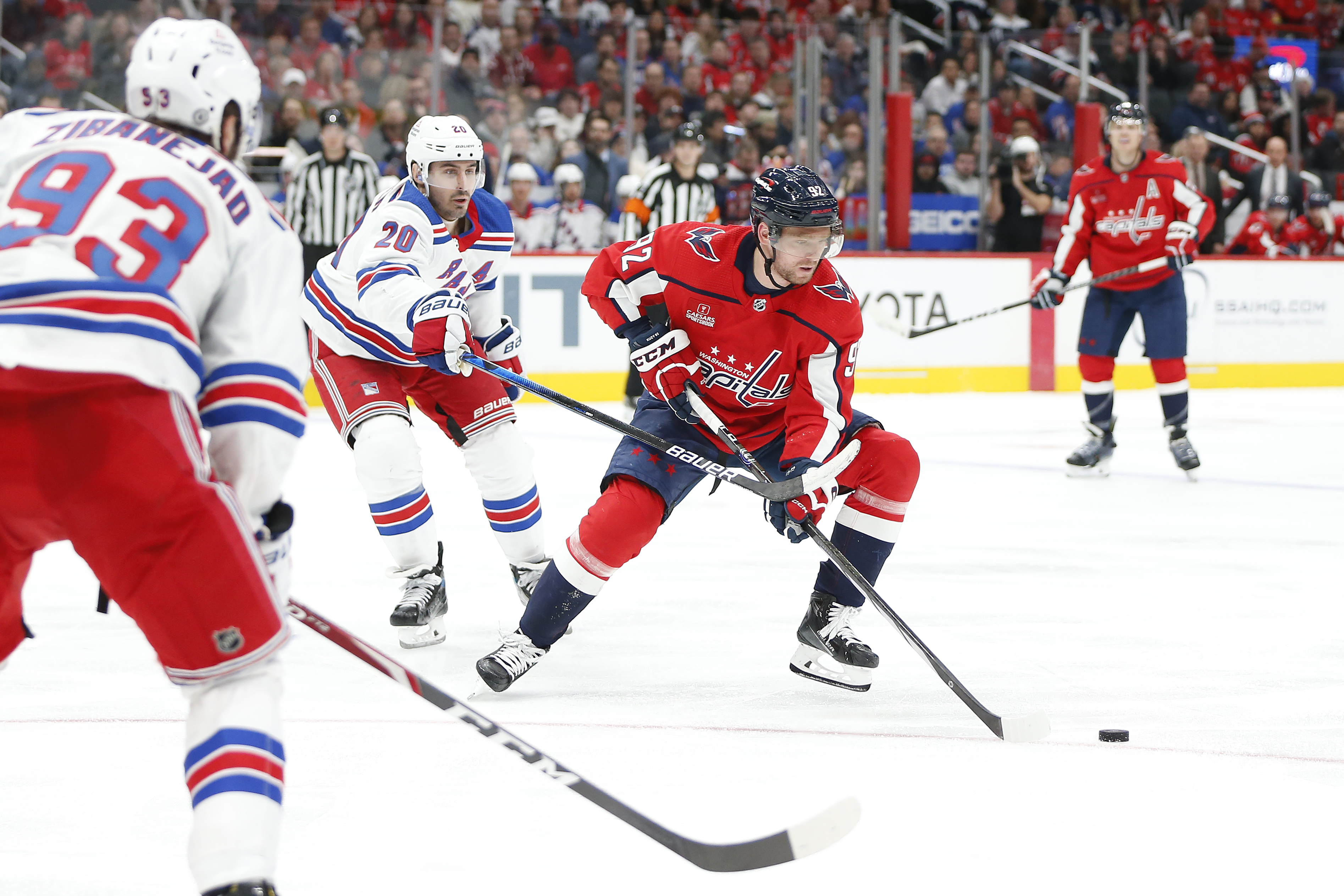 Washington Capitals center Evgeny Kuznetsov (92) skates with the puck as New York Rangers left wing Chris Kreider (20) defends during the third period at Capital One Arena