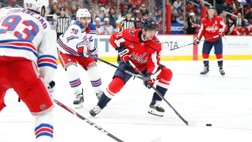 Washington Capitals center Evgeny Kuznetsov (92) skates with the puck as New York Rangers left wing Chris Kreider (20) defends during the third period at Capital One Arena