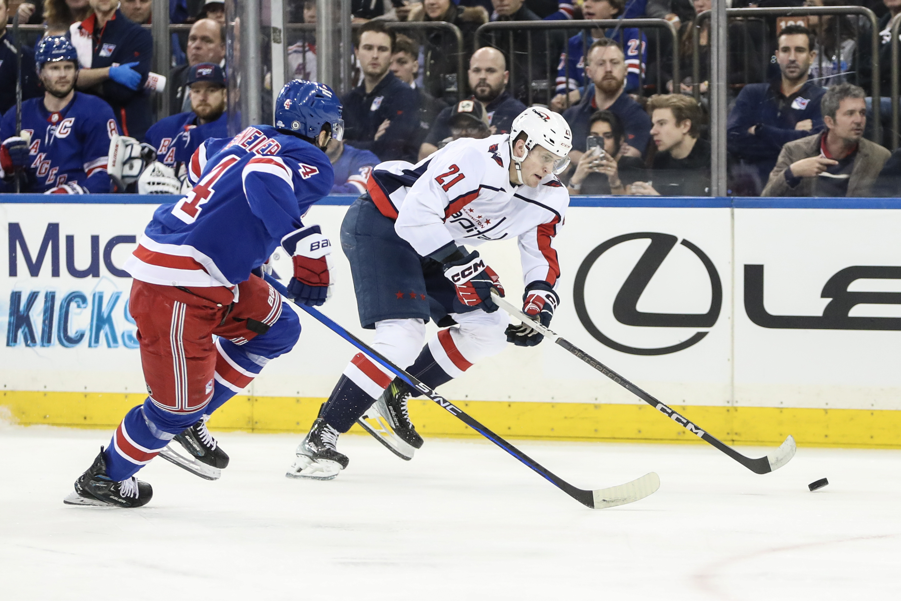 Washington Capitals center Aliaksei Protas (21) skates past New York Rangers defenseman Braden Schneider (4) in the first period at Madison Square Garden