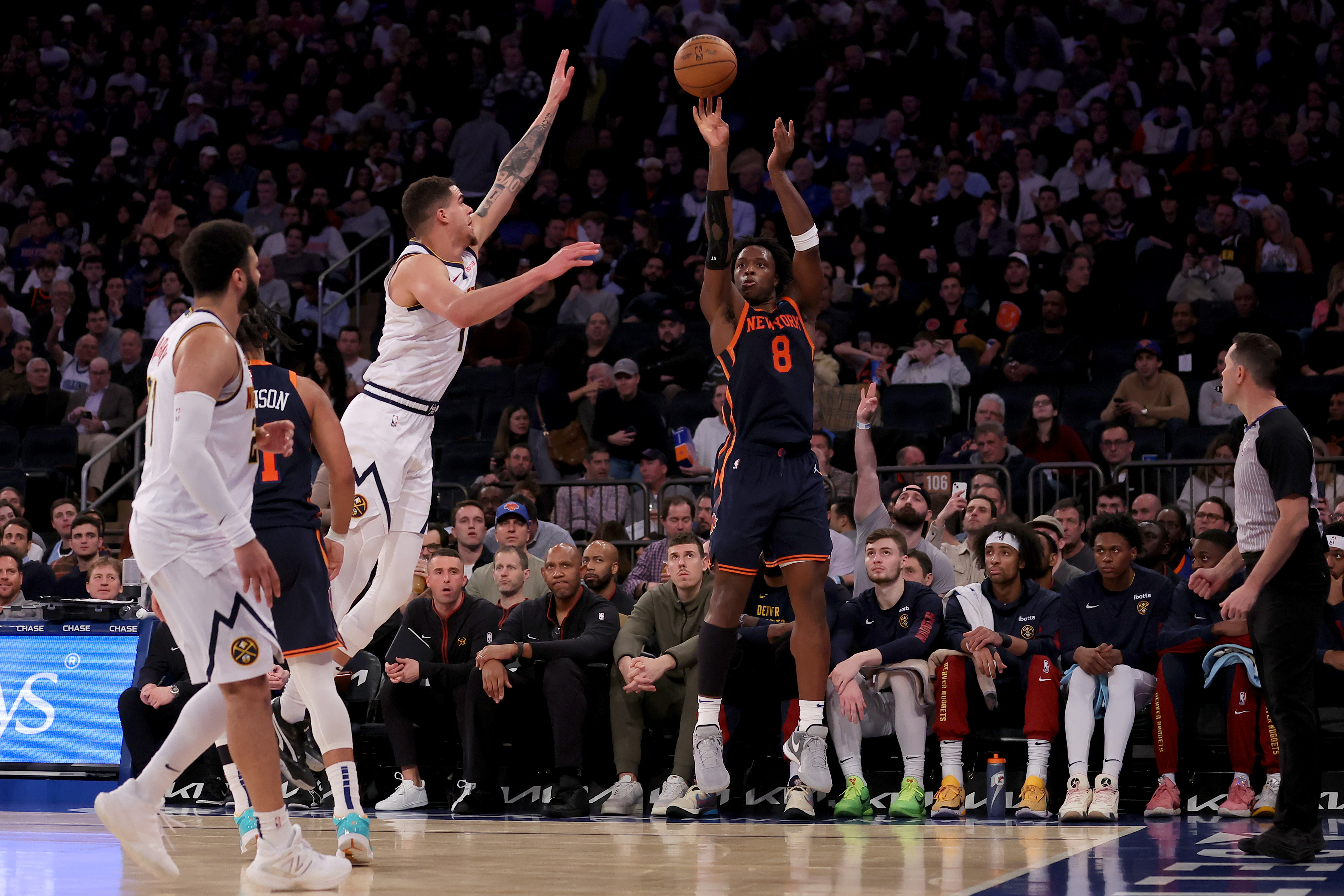 New York Knicks forward OG Anunoby (8) shoots a three point shot against Denver Nuggets forward Michael Porter Jr. (1) and Denver Nuggets guard Jamal Murray (27) during the third quarter at Madison Square Garden