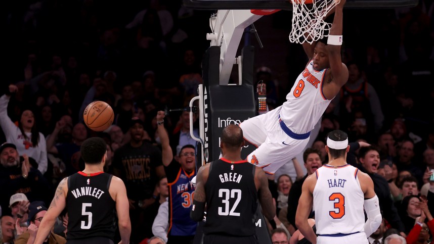 New York Knicks forward OG Anunoby (8) hangs on the rim after a dunk against Houston Rockets guard Fred VanVleet (5) and forward Jeff Green (32) during the fourth quarter at Madison Square Garden
