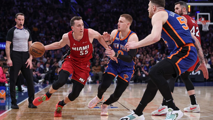 Miami Heat forward Duncan Robinson (55) dribbles against New York Knicks guard Donte DiVincenzo (0) and center Isaiah Hartenstein (55) during the first half at Madison Square Garden