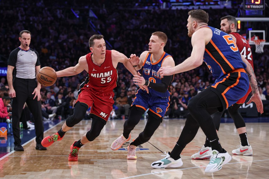 Miami Heat forward Duncan Robinson (55) dribbles against New York Knicks guard Donte DiVincenzo (0) and center Isaiah Hartenstein (55) during the first half at Madison Square Garden