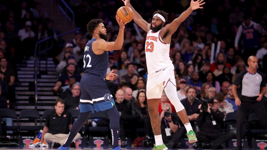 Minnesota Timberwolves center Karl-Anthony Towns (32) looks to pass the ball against New York Knicks center Mitchell Robinson (23) during the third quarter at Madison Square Garden