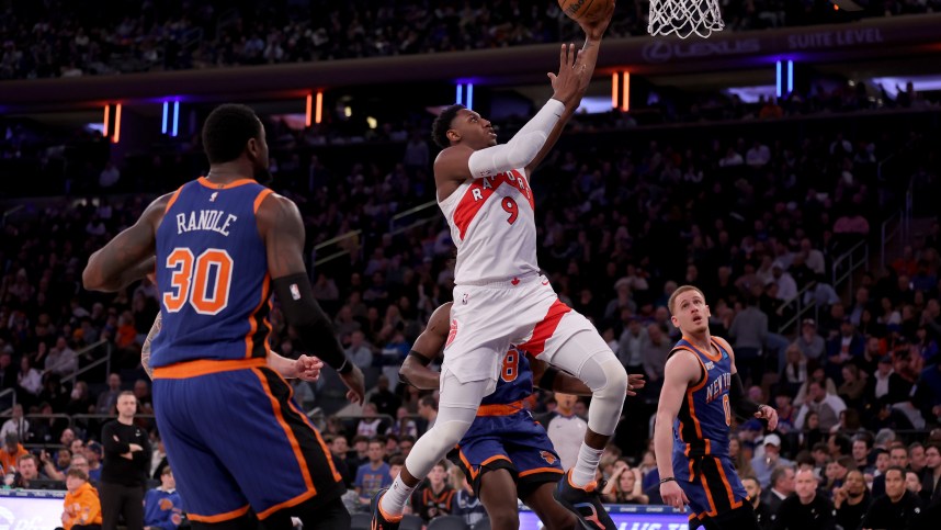 Toronto Raptors guard RJ Barrett (9) drives to the basket against New York Knicks forwards Julius Randle (30) and OG Anunoby (8) and guard Donte DiVincenzo (0) during the third quarter at Madison Square Garden