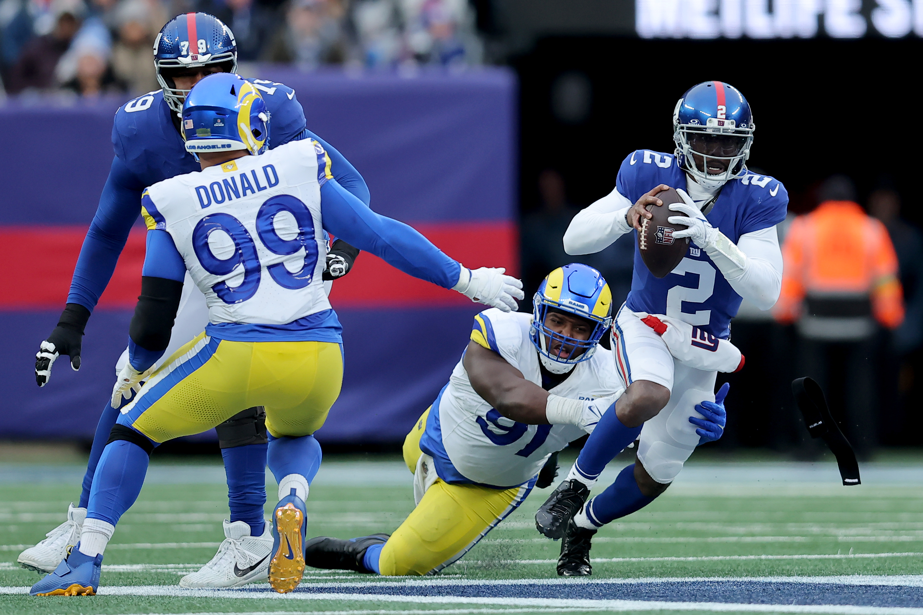 New York Giants quarterback Tyrod Taylor (2) is sacked by Los Angeles Rams defensive tackles Kobie Turner (91) and Aaron Donald (99) during the third quarter at MetLife Stadium