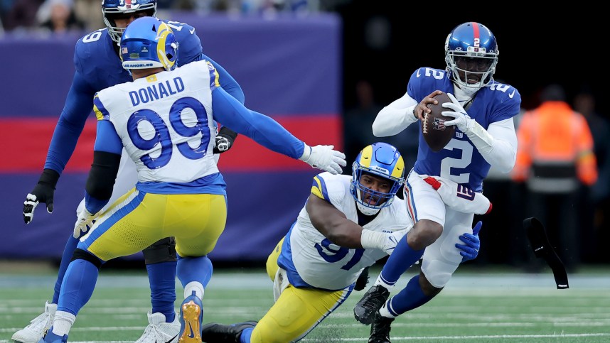 New York Giants quarterback Tyrod Taylor (2) is sacked by Los Angeles Rams defensive tackles Kobie Turner (91) and Aaron Donald (99) during the third quarter at MetLife Stadium