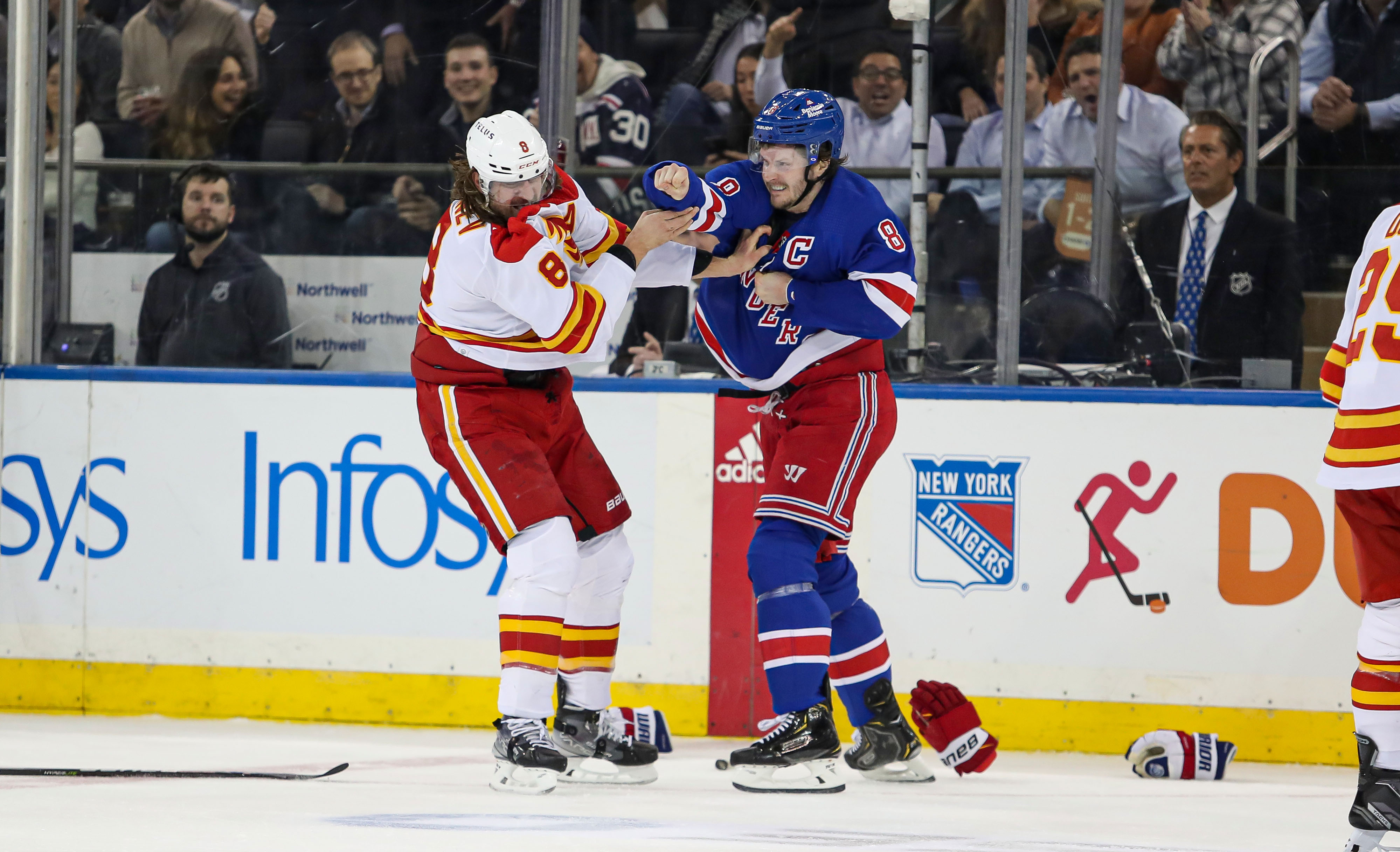 New York Rangers defenseman Jacob Trouba (8) and Calgary Flames defenseman Chris Tanev (8) fight during the first period at Madison Square Garden