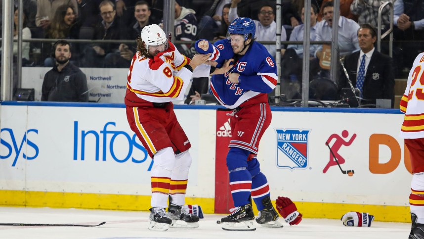 New York Rangers defenseman Jacob Trouba (8) and Calgary Flames defenseman Chris Tanev (8) fight during the first period at Madison Square Garden